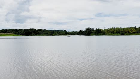 Hombre-En-Kayak-En-La-Distancia-En-Un-Lago-Tranquilo-En-Veraguas,-Panamá