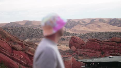 Rack-focus-from-Red-Rocks-Park-and-Amphitheatre-to-young-caucasian-male-with-round-bucket-hat-420-friendly