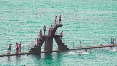 People-are-jumping-of-the-diving-board-at-the-seawater-swimming-pool-at-Plage-de-Bon-Secours
