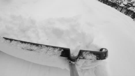 Using-large-shovel-to-remove-fresh-snow-from-walkway
