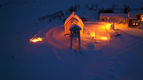 Orange-lit-church-in-a-thick-pack-of-snow-in-Iceland-at-night