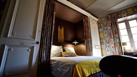 Glatte-Weitwinkelaufnahme-Eines-Farbenfrohen-Hotelzimmers-Mit-Einem-Großen-Bett-In-Natürlichem-Licht