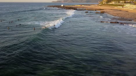 Mereweather-Beach-surfer-rides-shore-wave-at-sunrise,-Australia