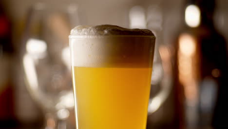 Close-up-of-craft-Beer-being-poured-in-to-a-pint-glass,-light-background