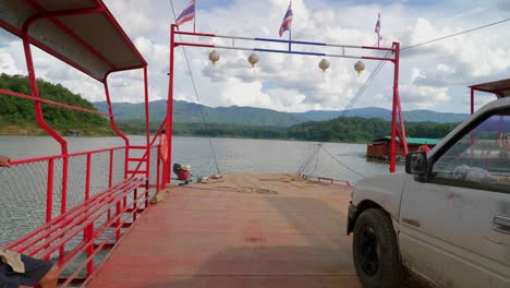 Shot-from-a-moving-barge-of-hill-yterrain-with-a-car-parked-on-it-in-Pak-Nai-fisherman-village,-Nan-province,-Thailand-on-a-cloudy-day