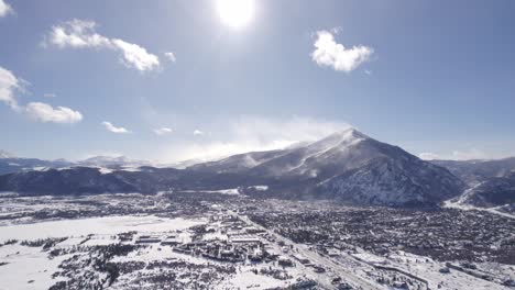 Aerial-Footage-of-Silverthorne,-Colorado-on-a-sunny-winter-day-with-Rocky-Mountains-in-background