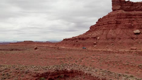 Car-driving-by-Rock-Formations,-Valley-of-the-Gods,-Utah,-United-States
