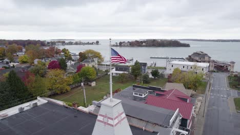 Patriotic-American-flag-waves-over-small-town-in-USA,-Put-in-Bay,-Ohio
