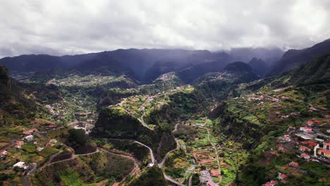 Aerial-panorama-of-green-mountain-valley-town-in-a-lush-green-landscape