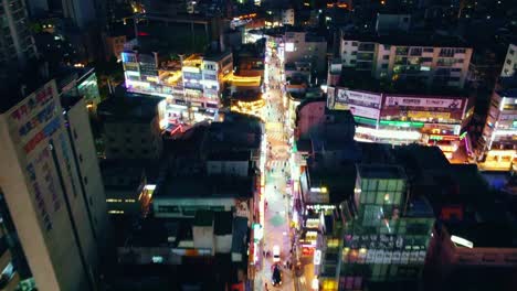 Aerial-Drone-View-of-Cyberpunk-City-Over-a-Shopping-Street-In-Korea-at-Night