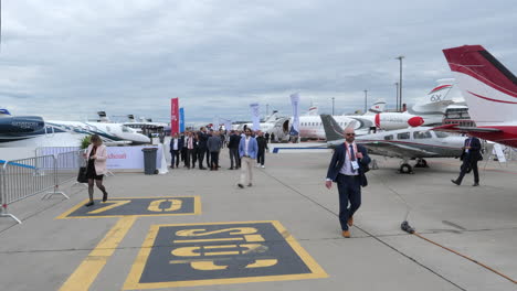 Aircraft-buyers-walking-around-exclusive-private-planes,-exhibited-at-airport