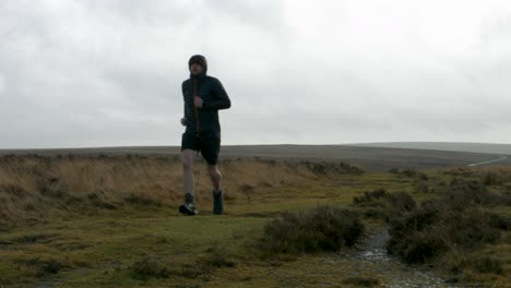Runner-Keeping-Healthy-Running-Past-Camera-Training-for-Marathon-in-Cold-Conditions-in-Moorland-Countryside-UK-4K
