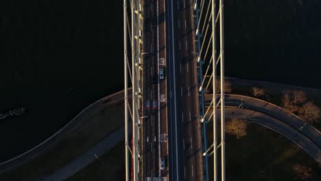 Vehicles-on-the-Verrazzano-Narrows-Bridge,-sunrise-in-NY,-USA---Aerial-tilt-shot