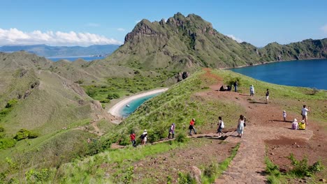 Tourist-exploring-the-tropical-uninhabited-Padar-Island-with-mountainous-and-turquoise-ocean-views-within-Komodo-National-Park,-Flores-Island,-Indonesia