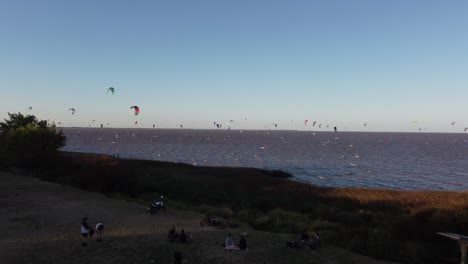Viele-Kitesurfer-Am-Fluss-Rio-De-La-Plata-Bei-Sonnenuntergang,-Vicente-Lopez-Area,-Buenos-Aires-In-Argentinien