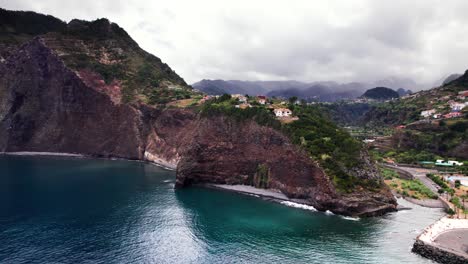 Aerial-view-of-a-house-on-edge-of-volcanic-rocky-cliff-coast,-Madeira