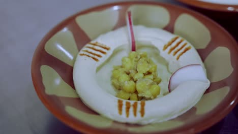 Decorating-Fresh-Hummus-Dish-With-Radish-All-Around-And-Cumin