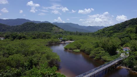 Aerial-view-over-a-bridge-on-the-Rio-Sahy-river,-in-sunny-Barra-Do-Sahy,-Brazil