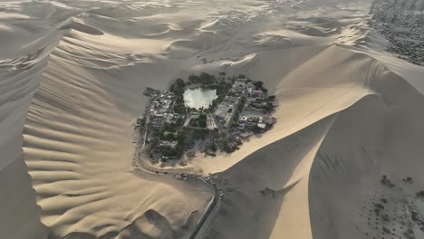 Orbit-Shot-Of-Isolated-Town-Surrounded-With-Sand-Dunes,-Ica,-Huacachina