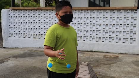 Indonesian-boy-playing-"Lato-lato",-popular-toy-in-Indonesia