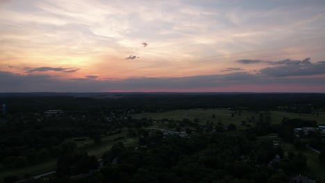 Aerial-time-lapse-of-clouds-passing-over-Bloomington,-Indiana-at-sunset