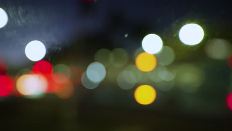 City-lights-out-of-focus-at-night-from-inside-a-moving-car