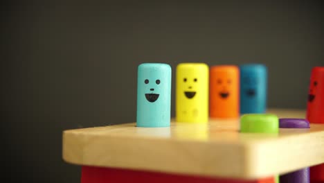 A-shot-of-different-color-wooden-kids-toys-with-smiley-faces-on-them