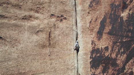 Aerial-View-of-Climber-on-Massive-Vertical-Rock-Trying-to-Climb-Up,-Drone-Shot