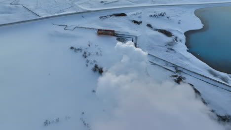 Fast-drone-dolly-shot-through-the-white-smoke-from-Myvatn-geothermal-installations-in-the-snowy-landscape-of-Iceland