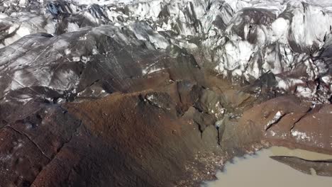 Environmental-scene-of-Glacier-covered-in-volcanic-ashes-in-Iceland,-aerial-view