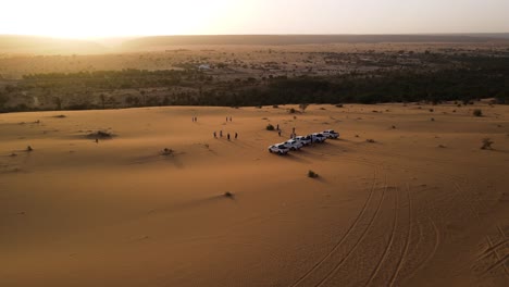 Tourist-Cars-in-Mauritania-Sahara-Desert-at-Sunset,-Cinematic-Aerial