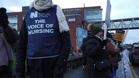 NHS-nurses-strike,-waving-banners-and-flags-demanding-fair-pay-rights-and-better-patient-care
