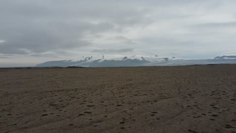 Desierto-Islandés-Con-Picos-Montañosos-Cubiertos-De-Nieve-En-El-Fondo