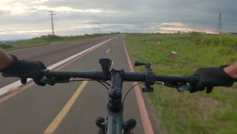 Cyclist-riding-on-the-bike-path-beside-the-highway,-first-person-video