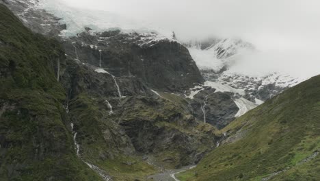 Imposing-Alpine-landscape-at-Rob-Roy-Glacier-waterfalls,-New-Zealand,-aerial