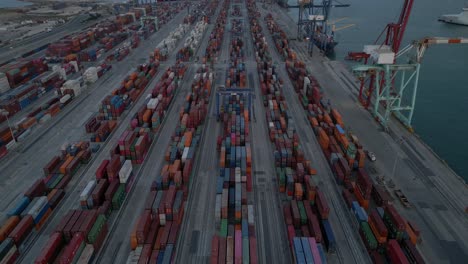 Revealing-Aerial-shot-of-shipping-Containers-Terminal-in-the-evening,-Valencia-Spain