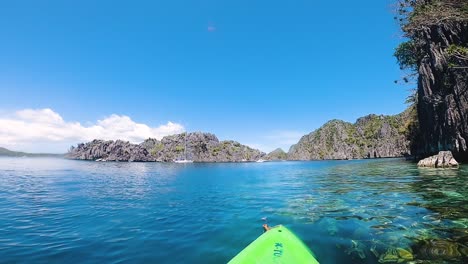 paddling-a-kayak-in-azure-sea-island-lagoon-between-mountains-in-Coron,-Palawan,-Philippines