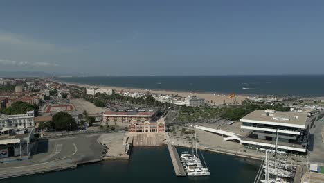 Revealing-Aerial-view-of-La-Marina-de-Valencia-summer-beach-and-Mediterranean-sea,-Spain