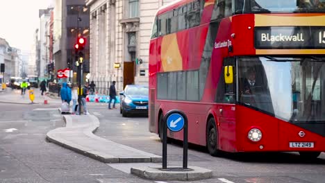 Londoner-überqueren-Die-Eastcheap-Street-Am-Denkmal,-Geschäftige-Urbane-Straßenszene-Mit-Vorbeifahrenden-Roten-Bussen