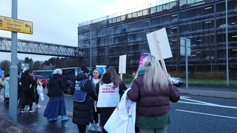 NHS-nurses-strike,-waving-flags-and-banners-demanding-fair-pay-and-better-patient-care