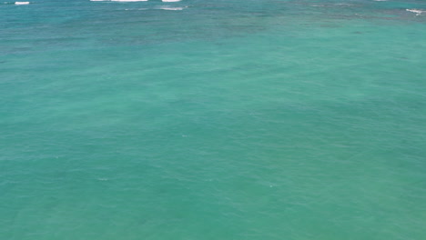 Aerial-drone-shot-over-deep-blue-ocean-along-Hawaii-coastline