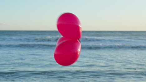 Drei-Rote-Luftballons-Ziehen-Am-Unscharfen-Meerblick-Vorbei