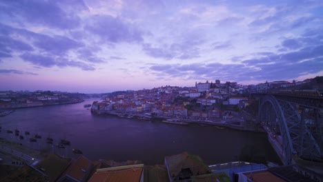 Porto,-Portugal,-Unesco-Heritage-Site,-old-city-houses-and-Douro-river-during-sunrise,-blue-hour-with-3-birds-flying-by