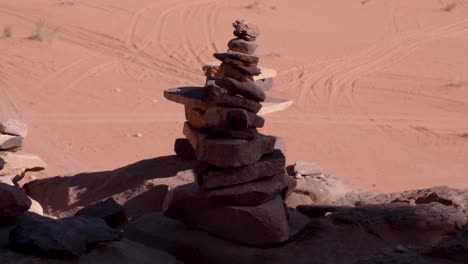 A-stack-of-rocks-and-stones-piled-up-overlooking-the-vast,-barren-desert-landscape-of-Wadi-Rum-in-Jordan,-Middle-East