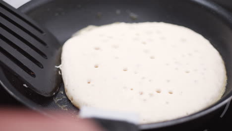 Pancake-Pikelet-Flipped-On-A-Frying-Pan-Outdoors,-SLOW-MOTION