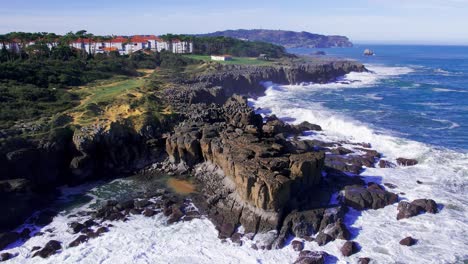 Aerial-view-of-the-hotels-and-rocky-cliff-near-the-coast-in-Cantabria,-Spain