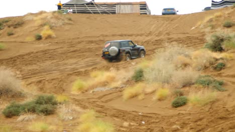 Video-of-a-car-racing-up-a-steep-hill-in-the-sand-dunes,-showcasing-the-car's-speed-and-agility-as-it-navigates-the-challenging-terrain