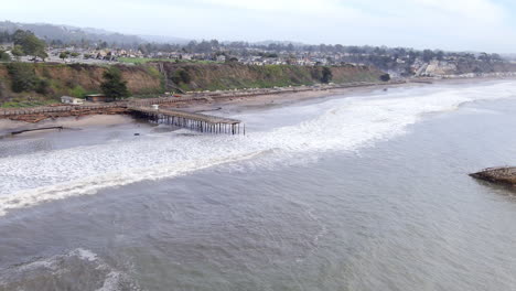 Seacliff-bomb-cyclone-pier-storm-damage-on-the-Santa-Cruz-coastline,-Aerial-view-over-strong-stormy-waves