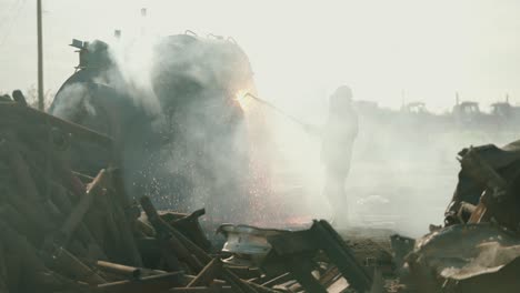 Metal-Torcher-cutting-metal-at-a-scrap-yard-in-slow-motion-with-fire-and-sparks