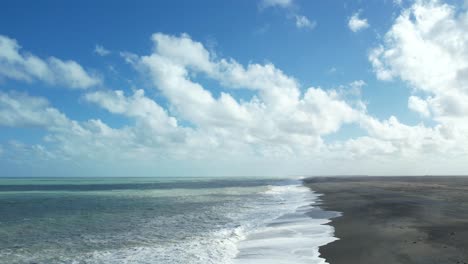 Aerial-reverse-with-cloud-shadows-on-turbulent-ocean-at-Birdlings-Flat-Beach